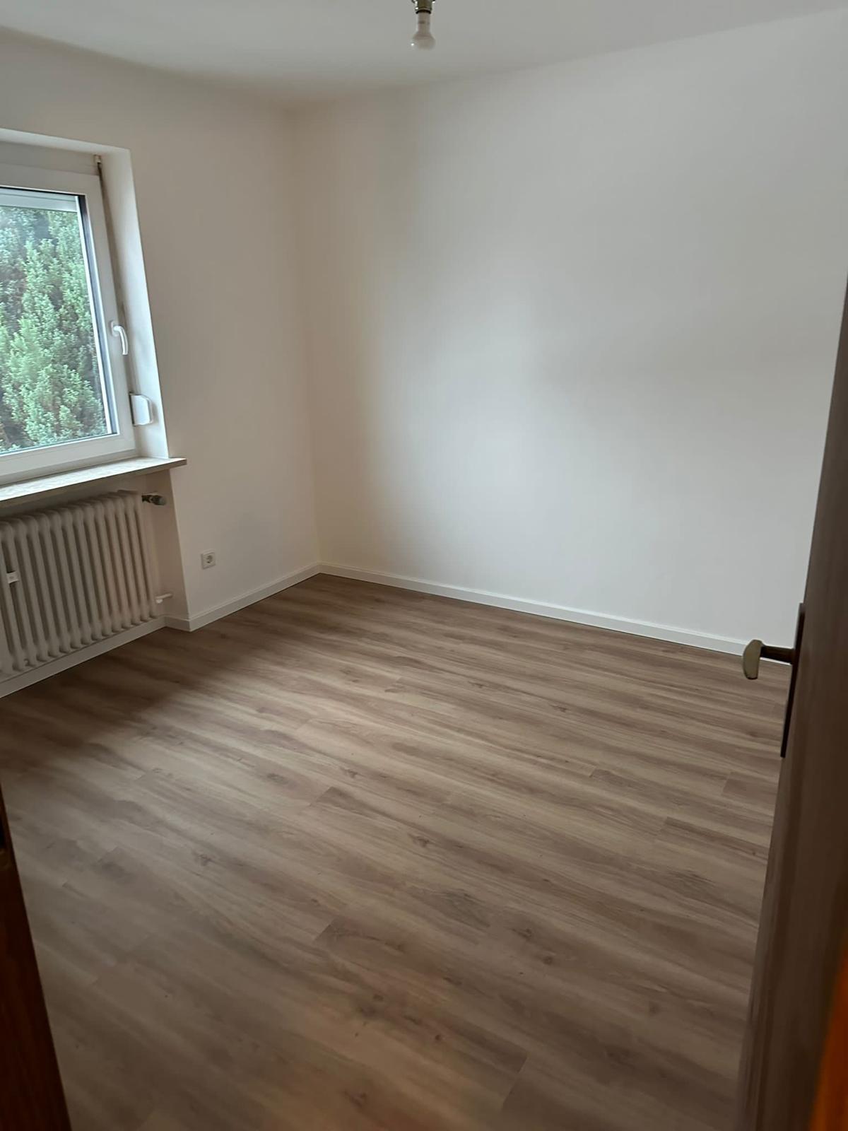 Renoviertes Zimmer mit neu verlegtem Vinylboden in heller Holzoptik und weiß gestrichenen Wänden – saubere Bodenarbeiten für modernes und wohnliches Raumgefühl.