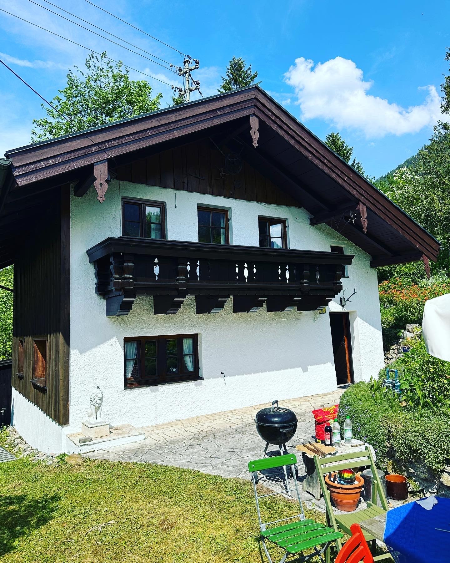 Renovierte Hausfassade eines traditionellen Einfamilienhauses mit dunklem Holz und weißem Putz – fachgerechte Fassadenarbeiten für langlebigen Wetterschutz und gepflegtes Erscheinungsbild.